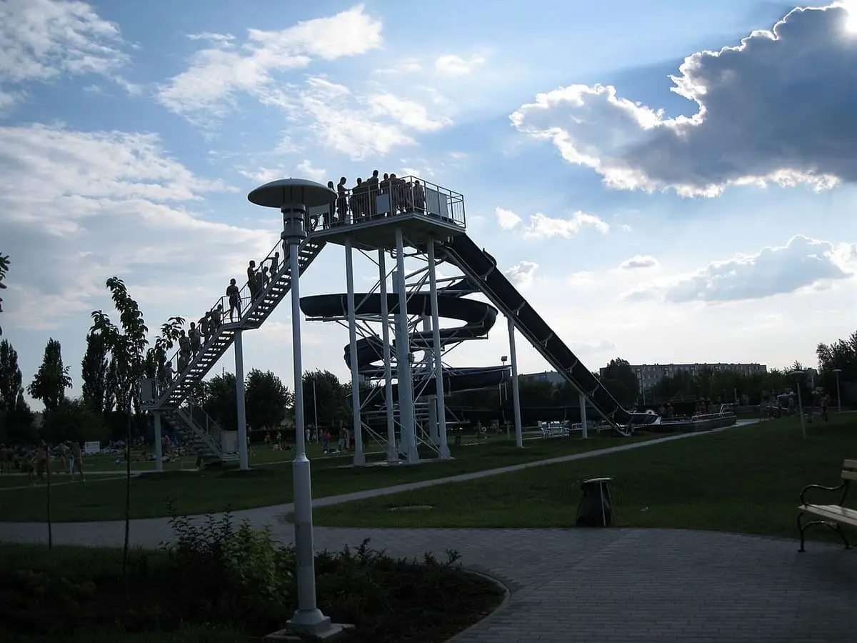 Water slide tower rising above lawns at the Tiszaújváros beach bath