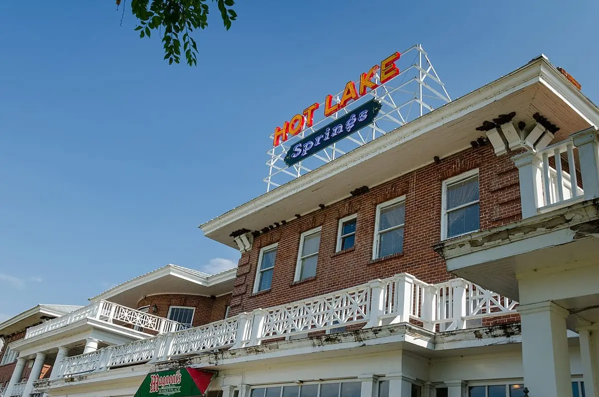 Hot Lake Springs neon rooftop sign above the brick resort building and its white balconies