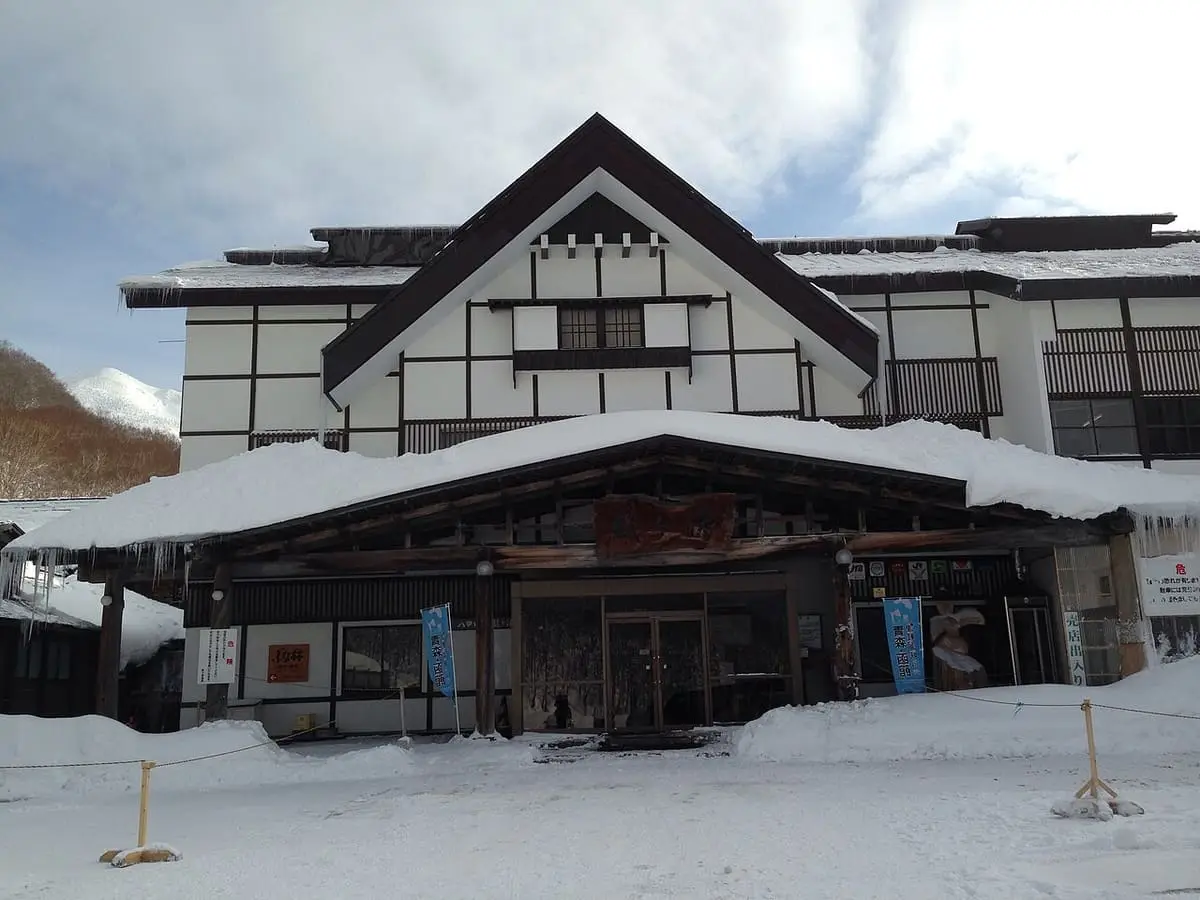 Sukayu Onsen inn with timbered gables and snow piled along the front in winter