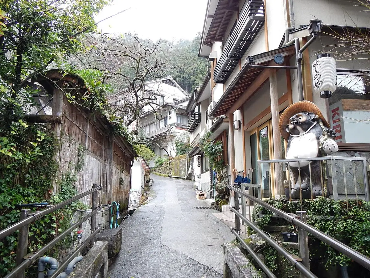 Narrow lane past wooden inns climbing through Yunomine Onsen