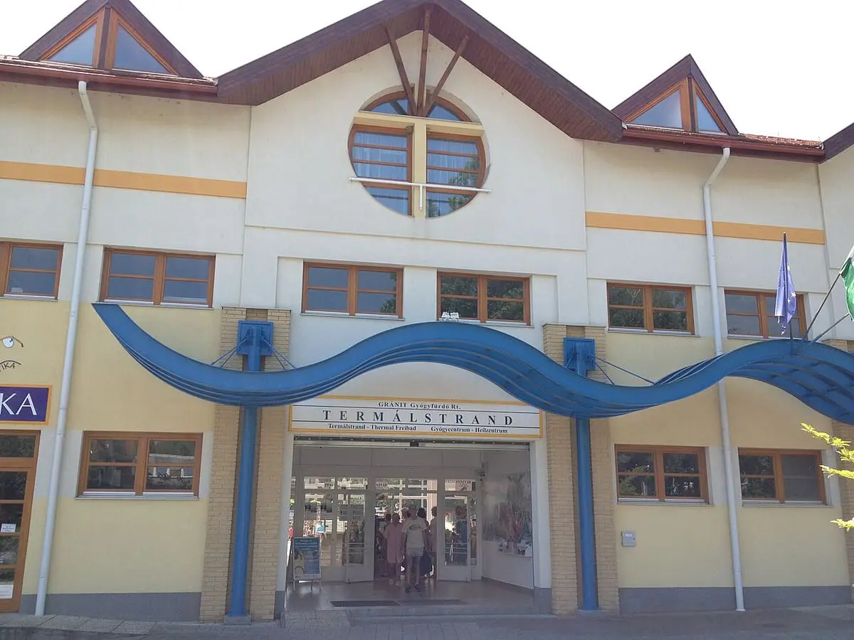 Yellow entrance building of the Zalakaros Termálstrand with a blue wave shaped canopy