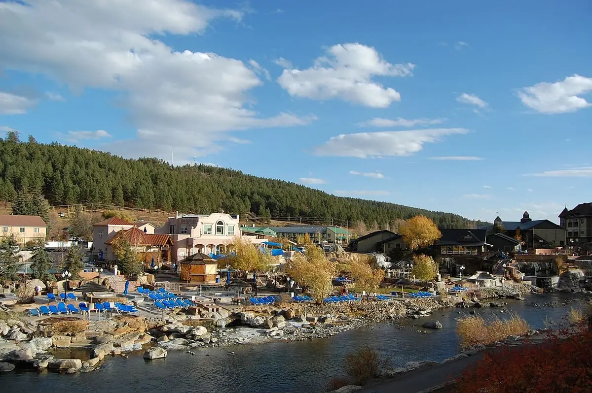 Terraced soaking pools of The Springs Resort beside the San Juan River under autumn trees