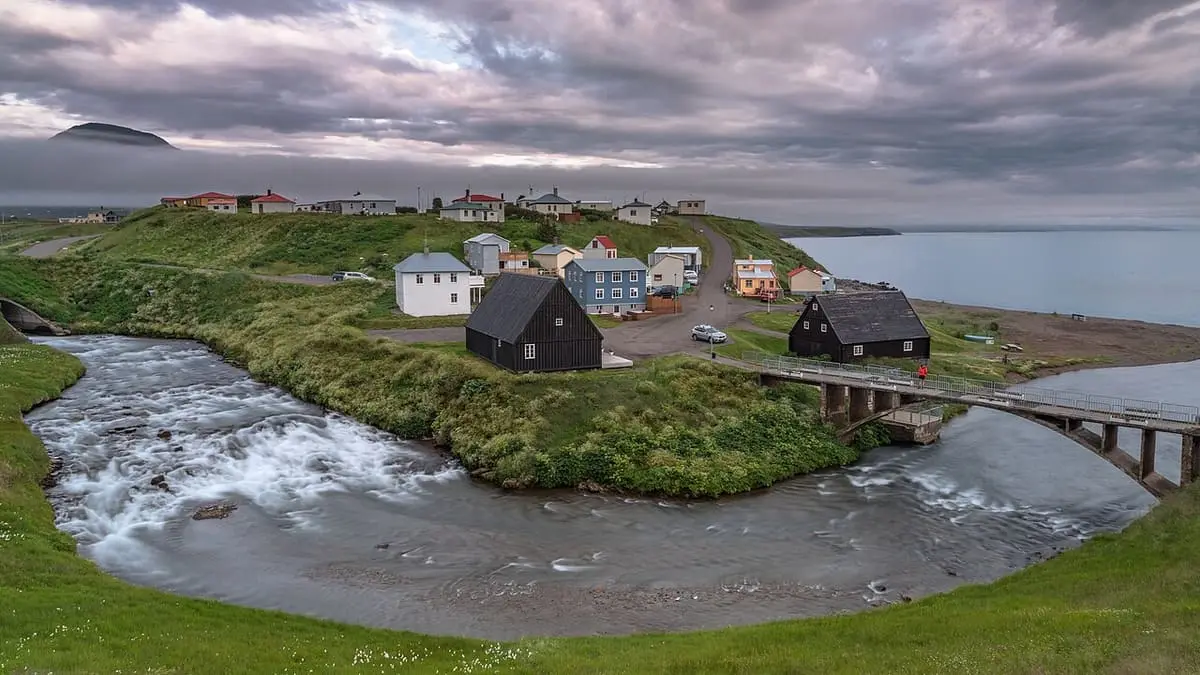 Hofsós village with old wooden houses and a bridge over the river mouth by the fjord