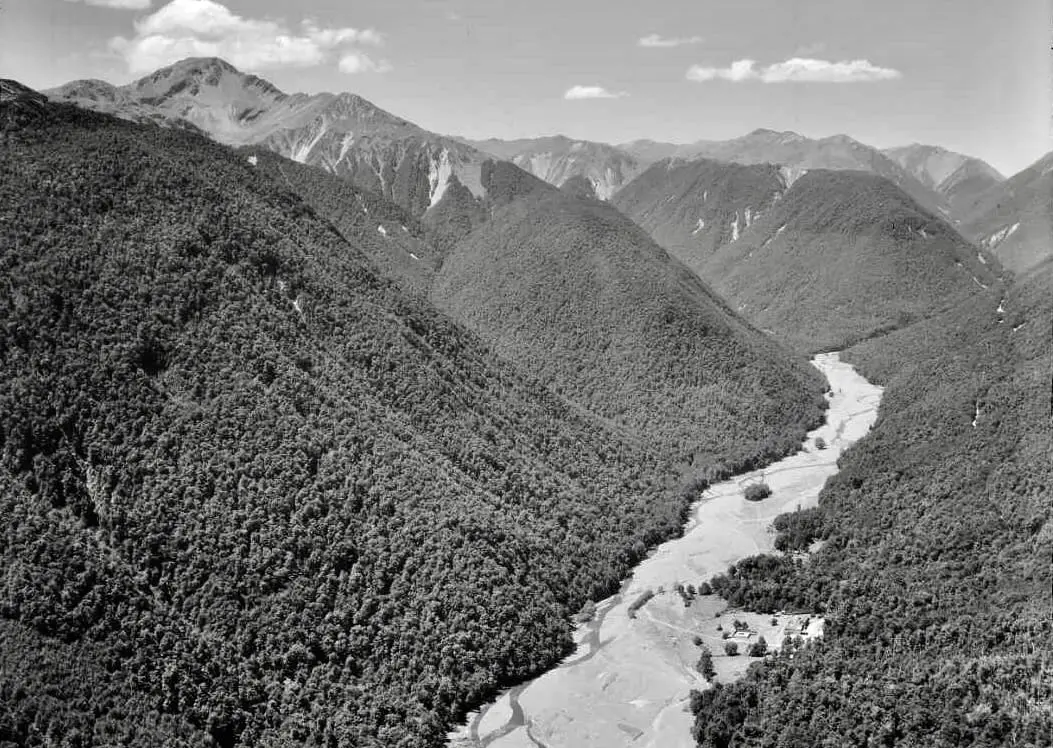 Historic black and white aerial view of the Maruia valley with the Maruia Springs buildings beside the river