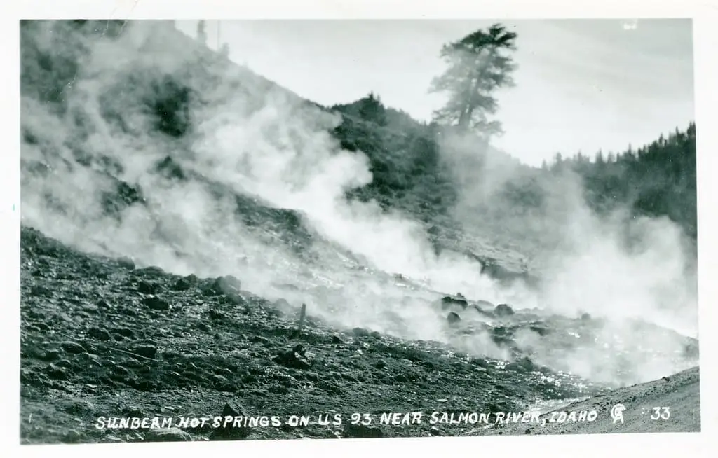 Historic postcard of steam rising from Sunbeam Hot Springs on the hillside near the Salmon River