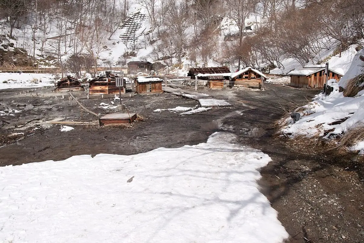 Source field of Nikko Yumoto Onsen with small huts over the springs in snow