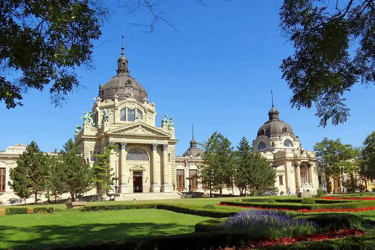 Main domed facade of the Széchenyi Thermal Bath behind flower beds in City Park