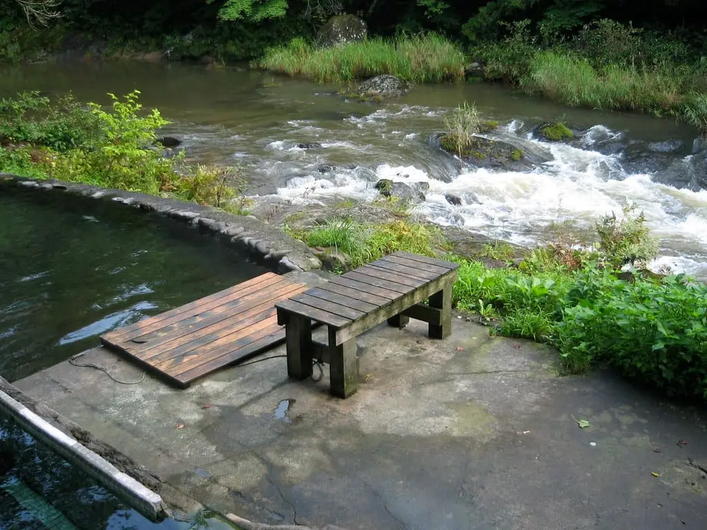 Riverside open air bath with wooden benches above the rushing Ohata River at Okuyagen
