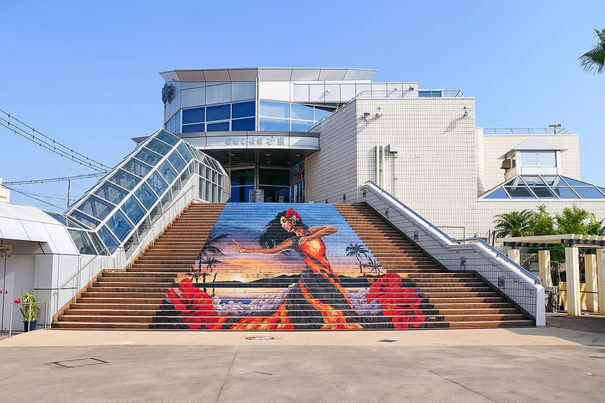 Saraku sand bath hall in Ibusuki with covered stairways and a painted mural on the front steps