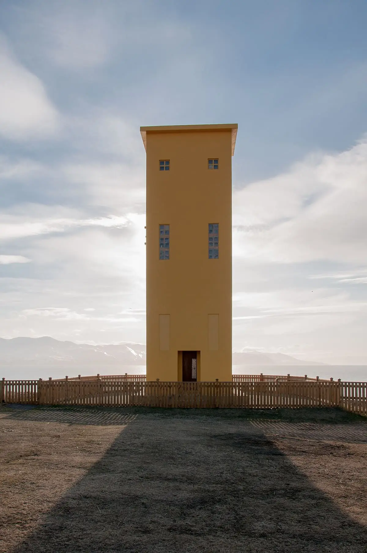 Yellow lighthouse on the headland above Húsavík harbour, next to the GeoSea baths