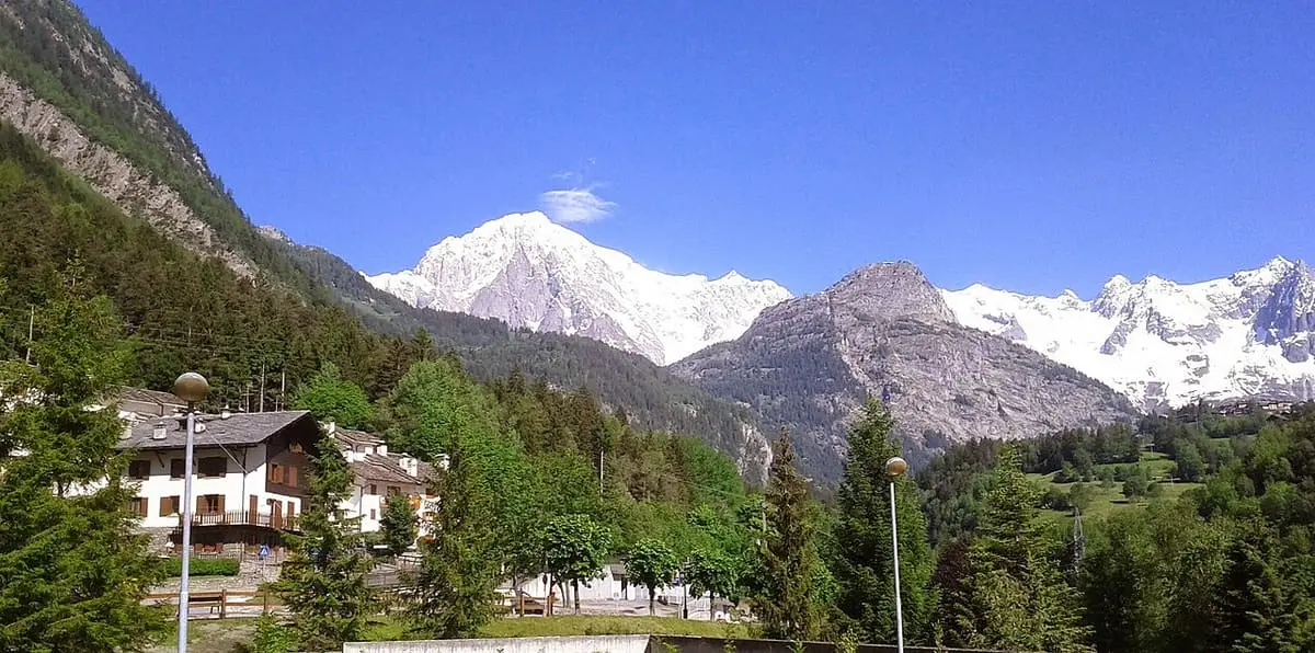 Snowy Mont Blanc massif rising above chalets and forest at Pré Saint Didier