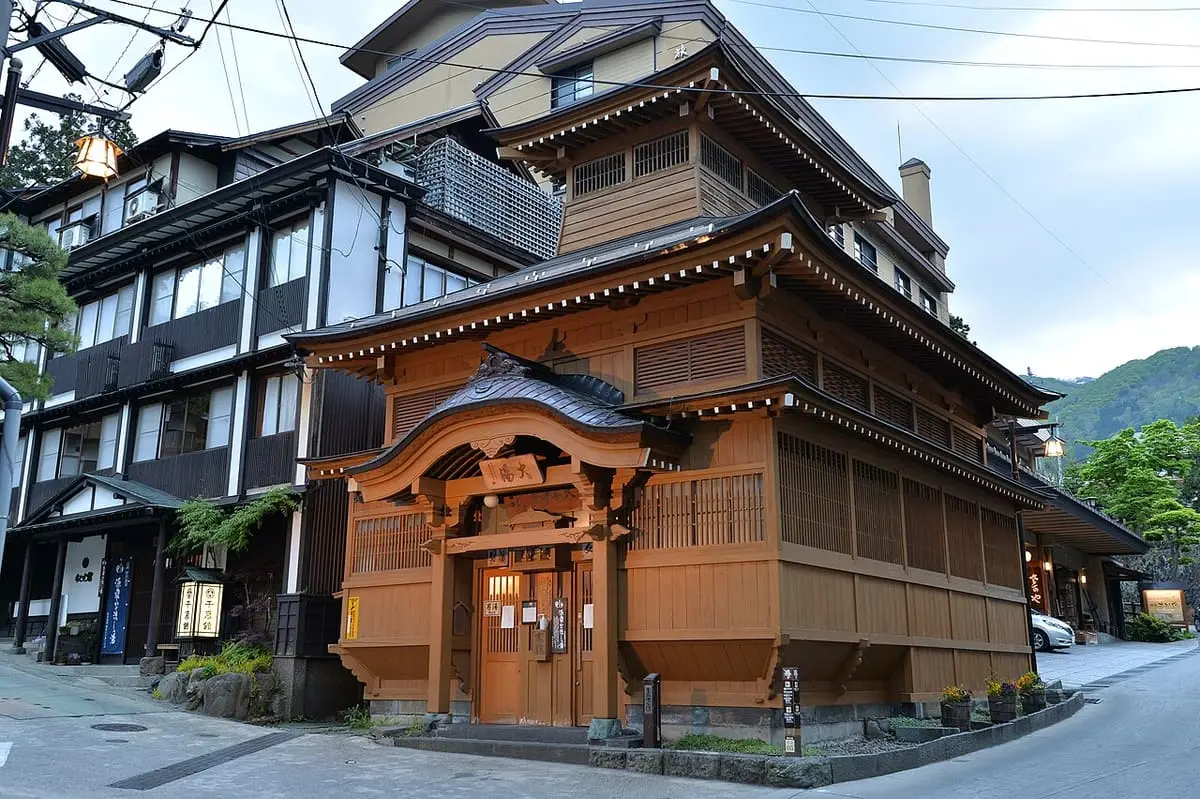 Ornate wooden Oyu public bathhouse on a village street in Nozawa Onsen