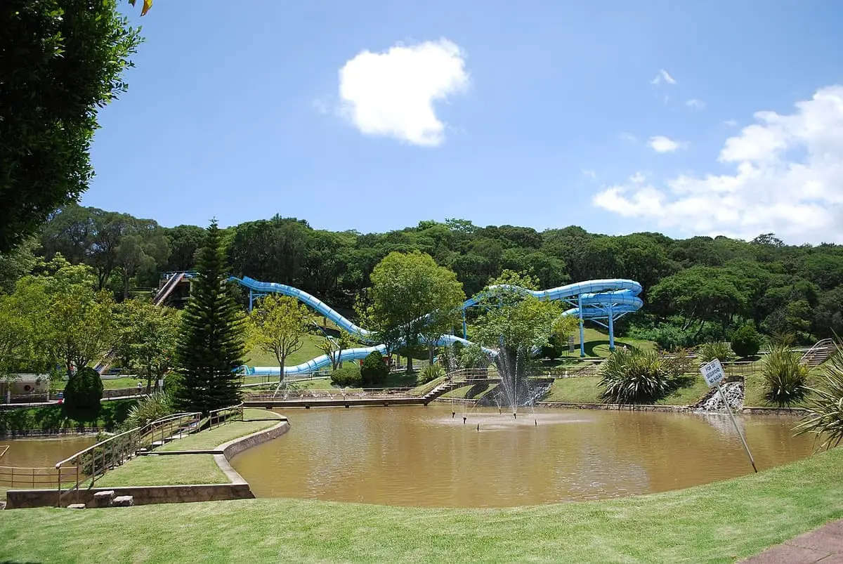 Blue tube water slides above a pond and lawns at Parque Acuático Ixtapan
