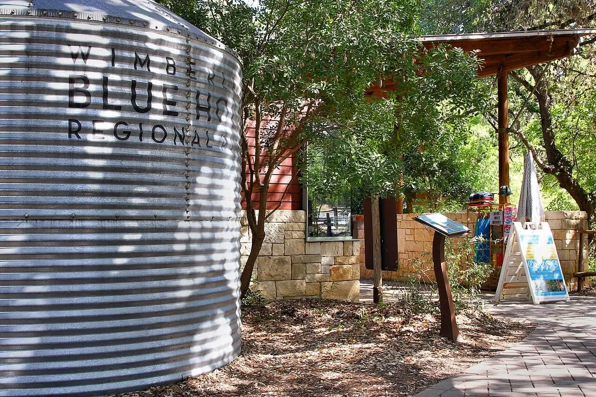 Entrance to the Cypress Creek swim area at Blue Hole Regional Park in Wimberley with a painted water tank