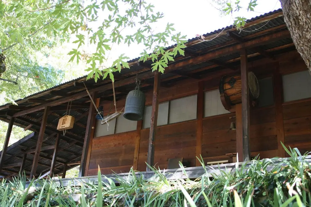 Wooden zendo at Tassajara with a bronze bell hanging under the eaves