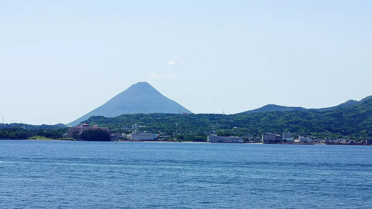 Ibusuki Onsen town along the bay with the cone of Mount Kaimon rising behind