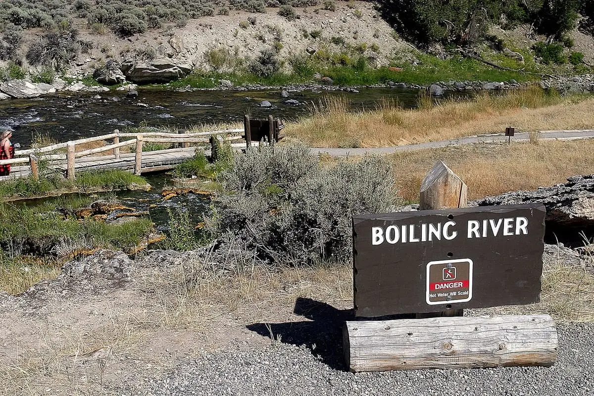 Boiling River sign with a scalding water warning beside the Gardner River and a footbridge