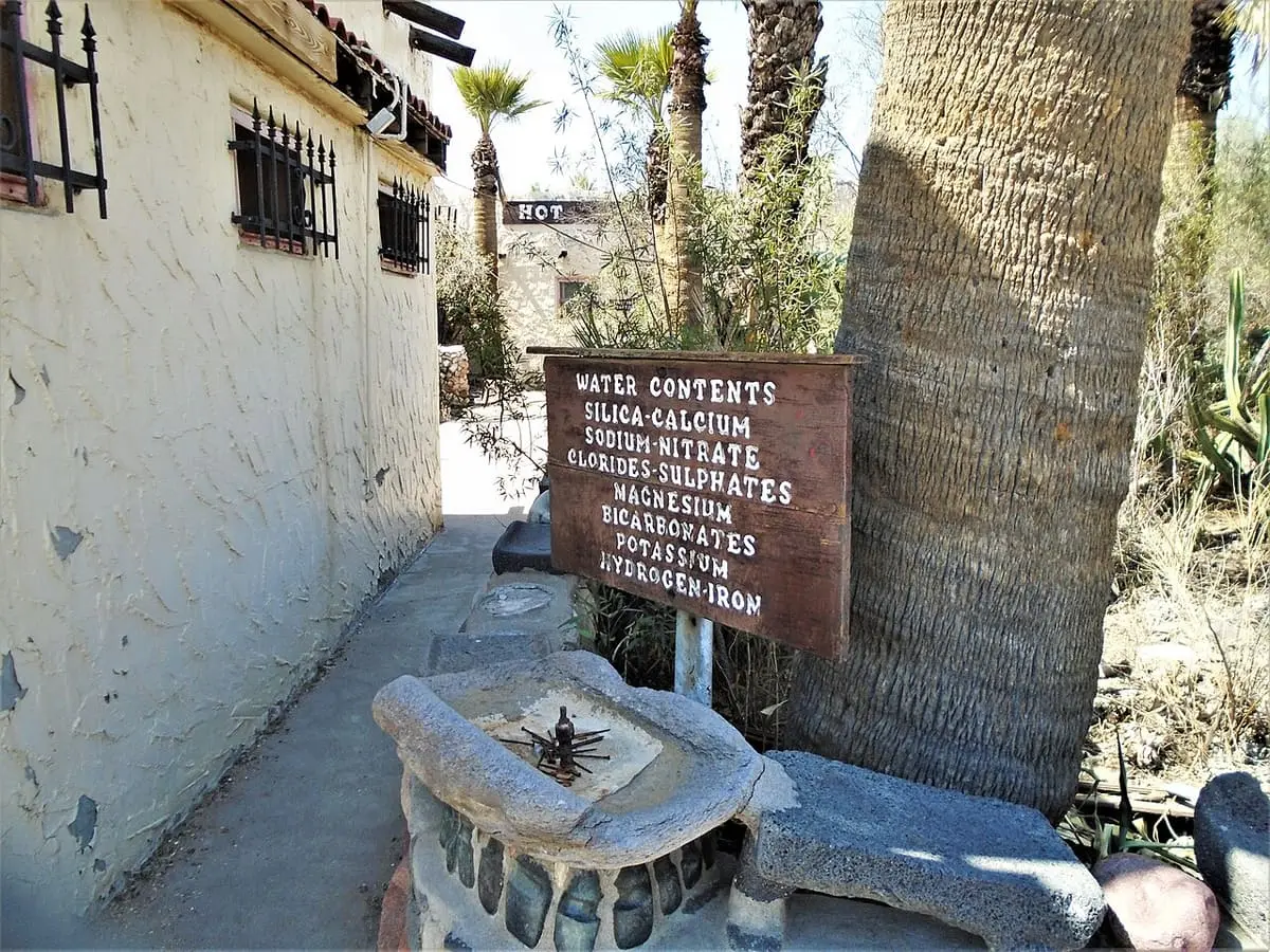 Water contents sign listing minerals beside a stone basin at the Buckhorn Baths in Mesa