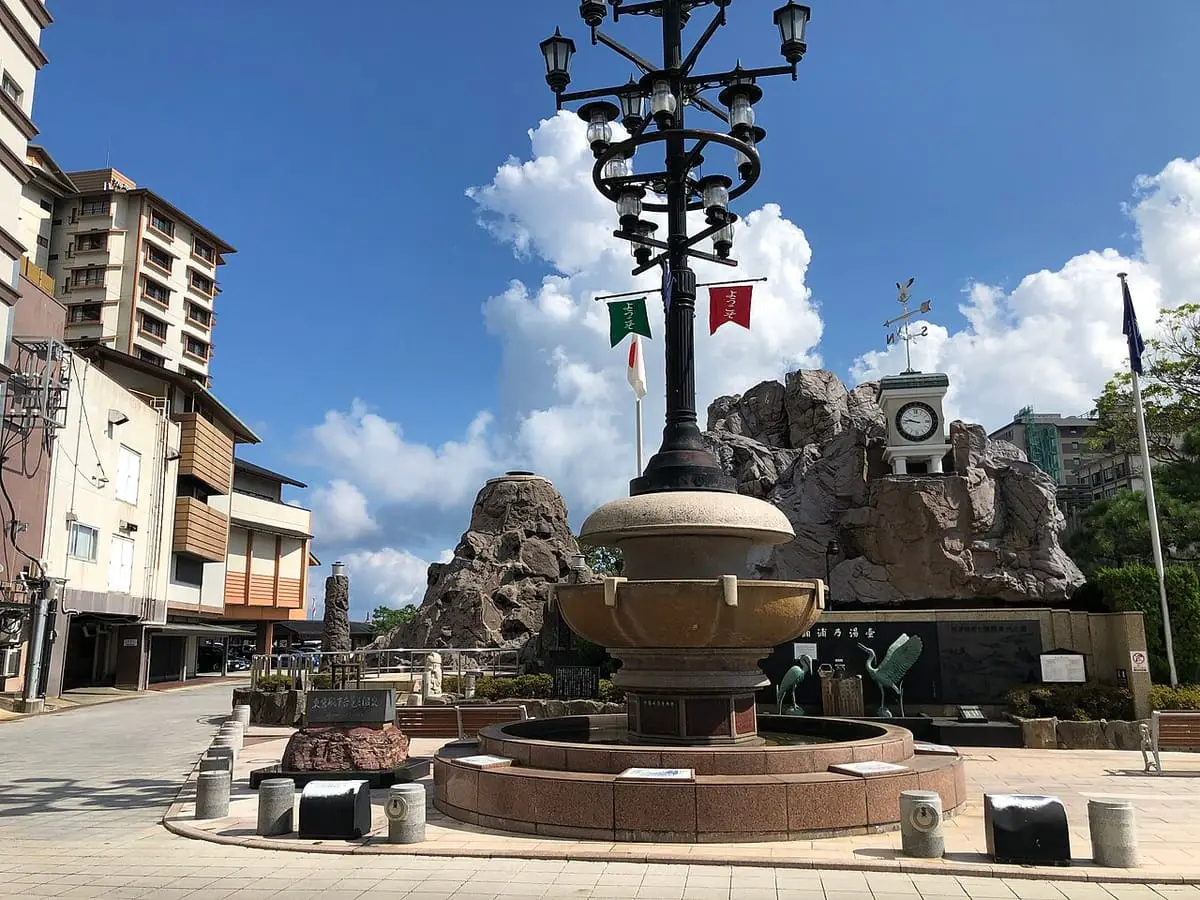 Stone fountain plaza on a street in Wakura Onsen town under summer clouds