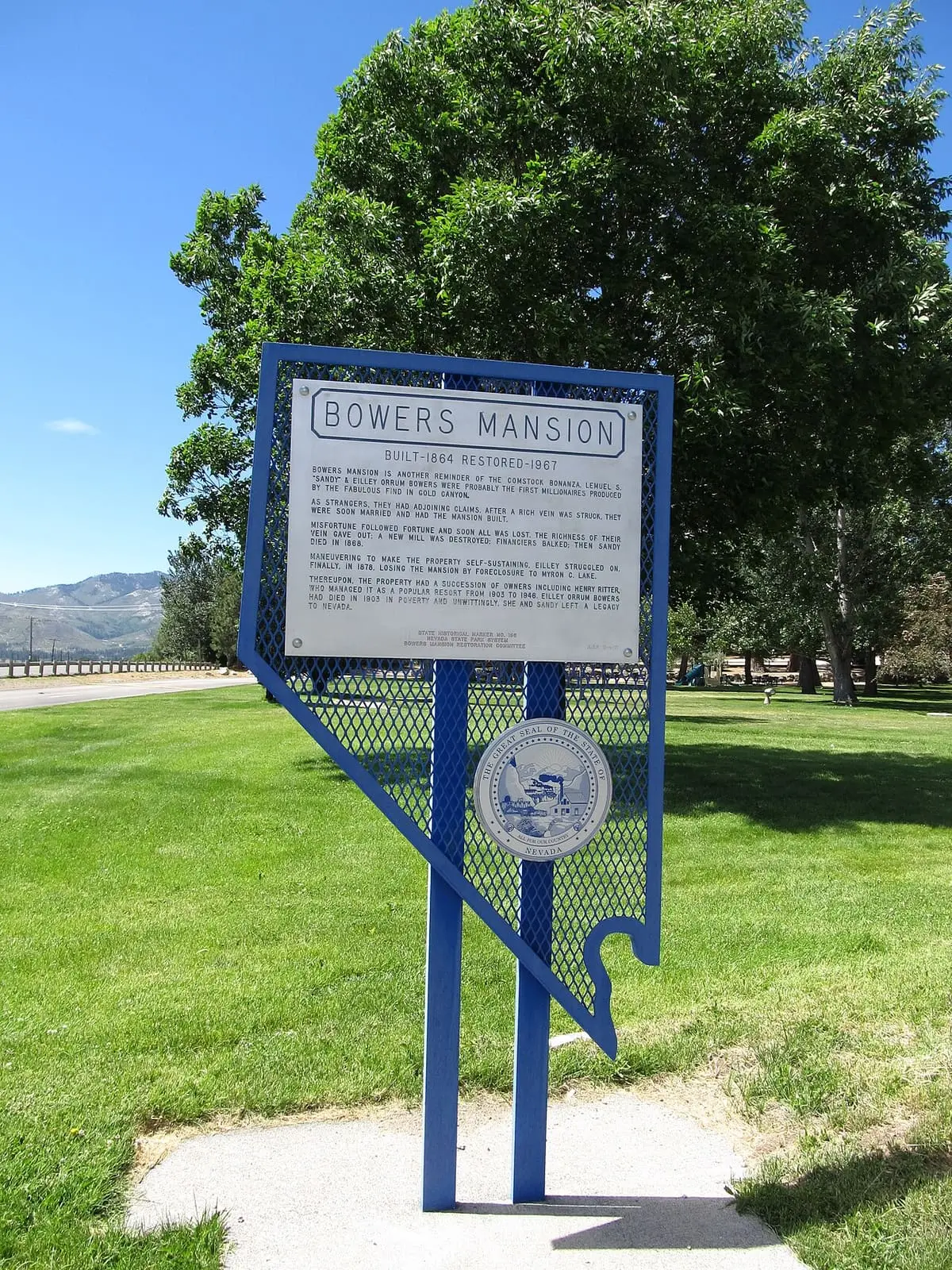 Blue Nevada historical marker sign for Bowers Mansion on a lawn in Washoe Valley