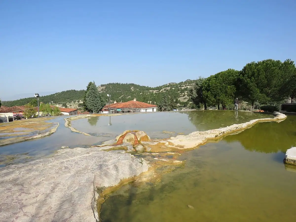 Shallow greenish thermal pools edged with travertine in the Karahayıt red spring park