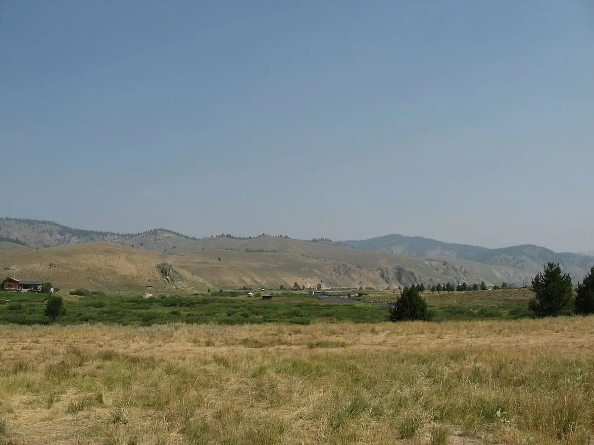 Grassy flats and rolling hills looking north from Stanley, Idaho, on a clear summer day