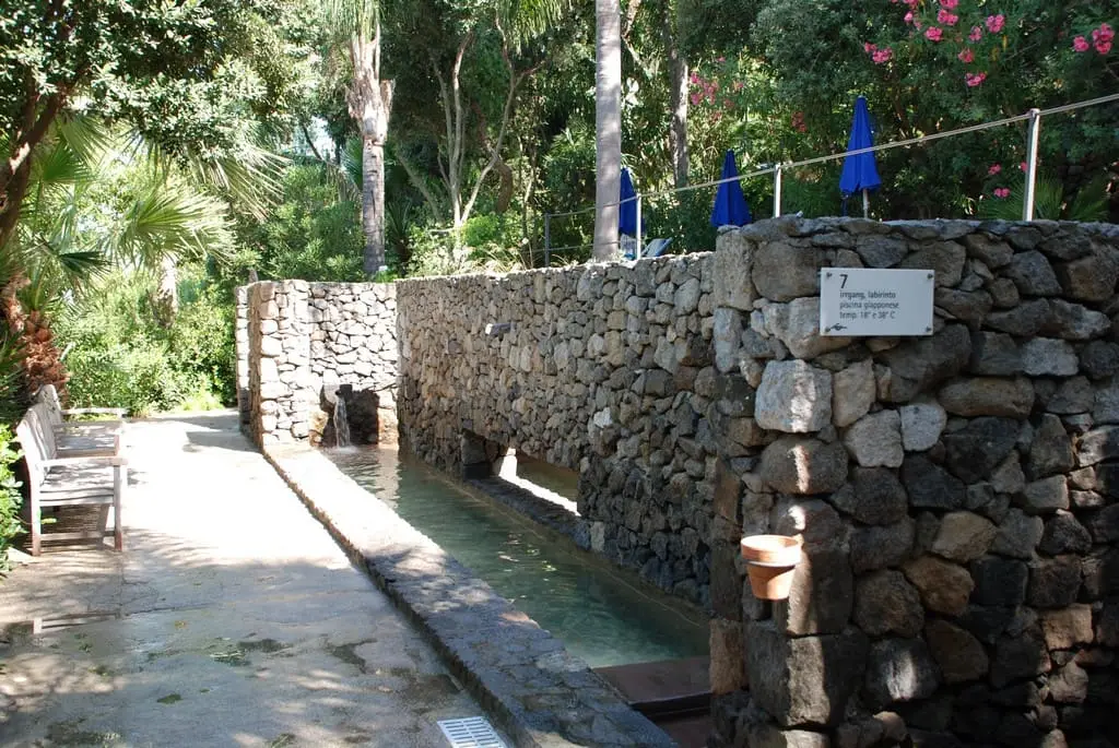 Long narrow Labirinto pool beside a stone wall in the Negombo thermal gardens