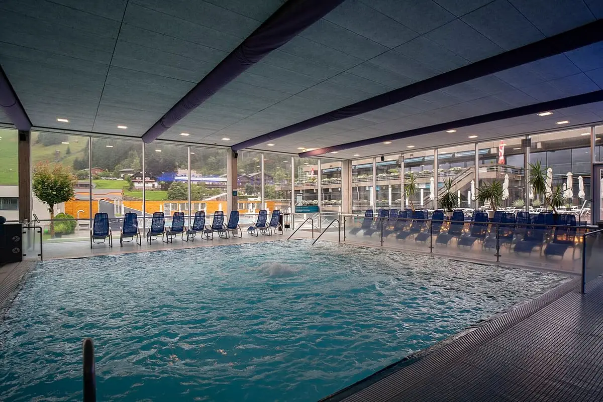 Bubbling indoor pool at the Felsentherme Bad Gastein with large windows onto the valley