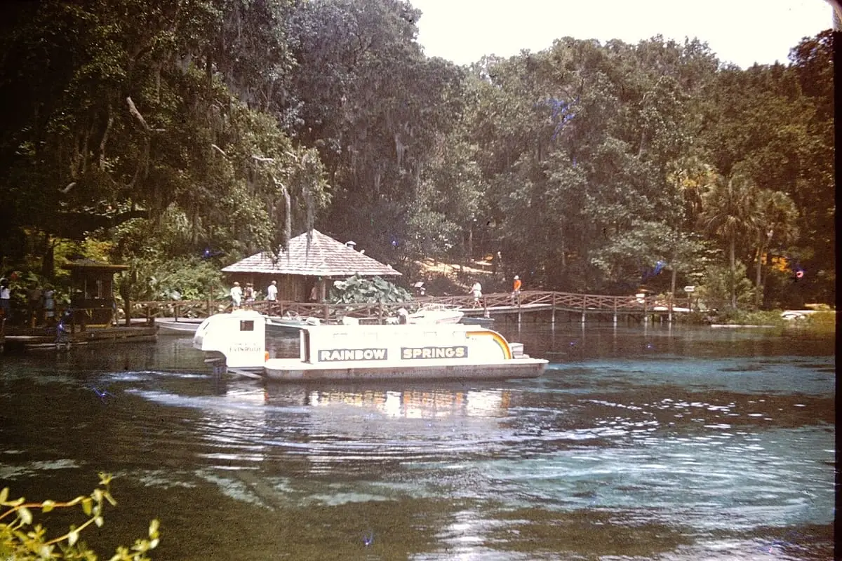 Historic Rainbow Springs sightseeing boat on the river around 1970 with a thatched landing behind