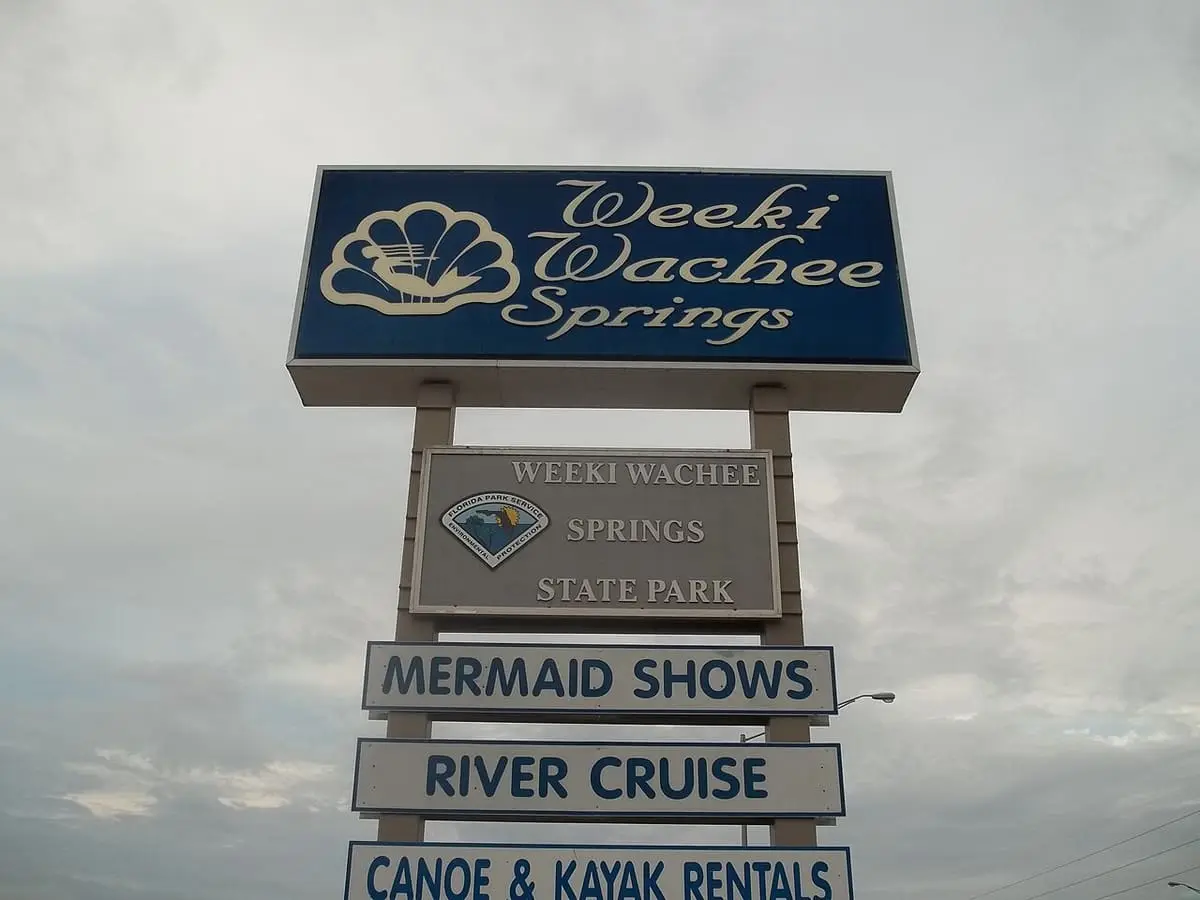 Weeki Wachee Springs State Park road sign listing mermaid shows, river cruise and kayak rentals