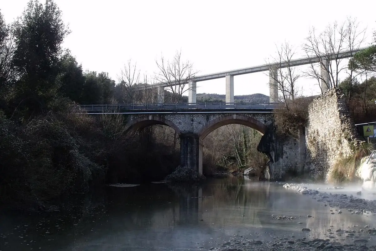Old stone arch bridge and modern viaduct over the Farma river near Bagni di Petriolo