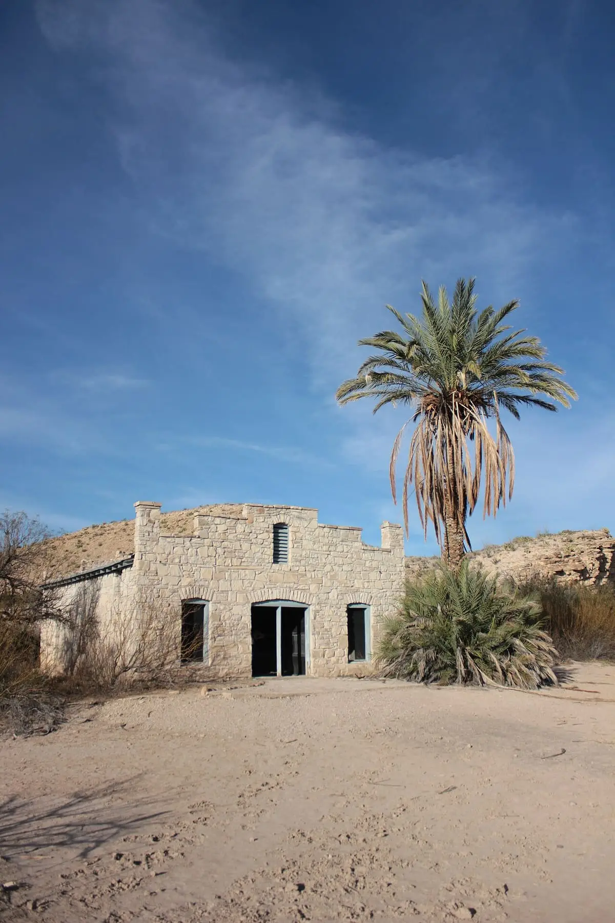 Historic Hot Springs post office and store building with a palm tree in Big Bend