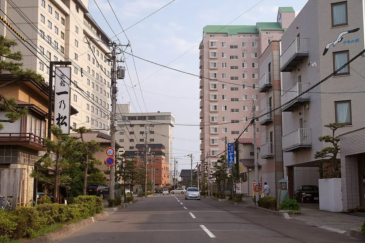 Street lined with hotels in Hakodate Yunokawa Onsen under blue sky