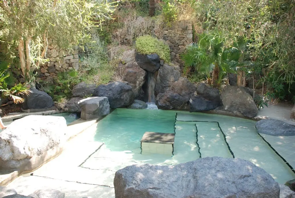 Rock edged Maya thermal pool with a small waterfall in the gardens of Parco Termale Negombo