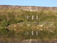 Spring water spilling from the Thousand Springs basalt cliffs and reflected in the Snake River near 1000 Springs Resort