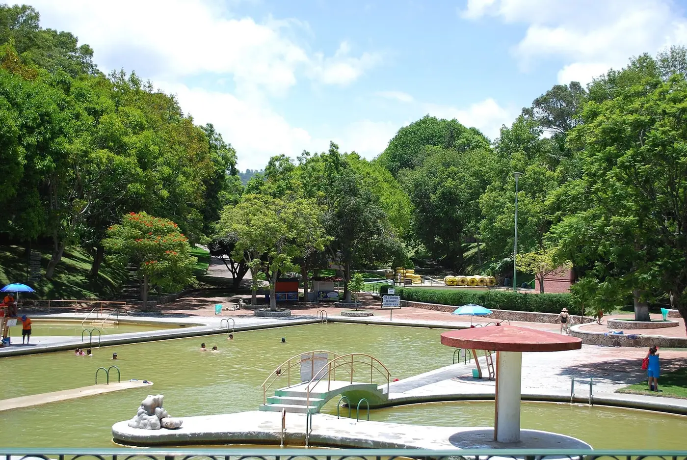 Shallow thermal water pools among shade trees at Parque Acuático Ixtapan in Ixtapan de la Sal