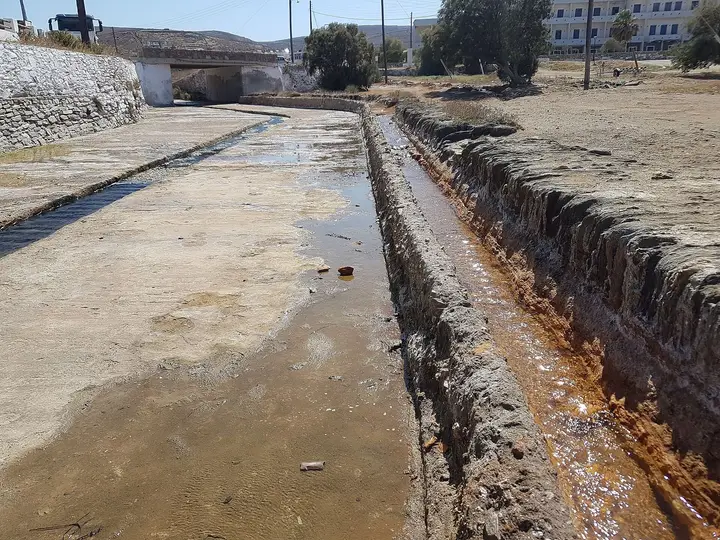 Hot spring water running through a rust stained stone channel at Loutra on Kythnos
