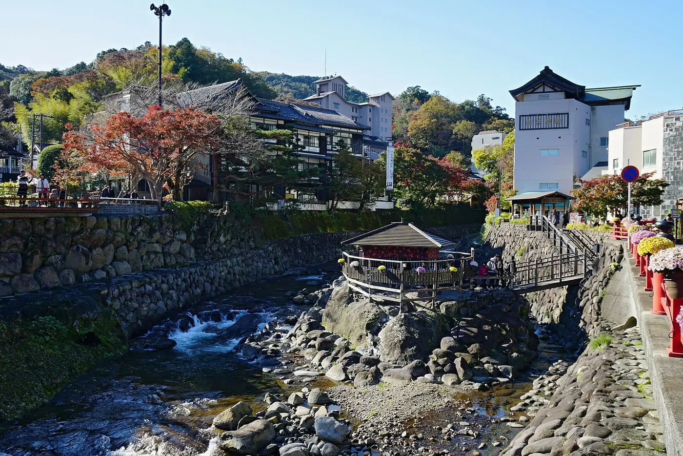 Shuzenji River flowing over rocks past the Tokko no Yu pavilion and onsen town buildings