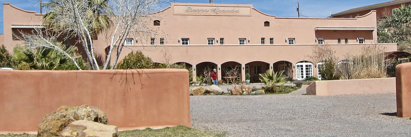 Arched stucco facade and walled courtyard of Sierra Grande Lodge in Truth or Consequences