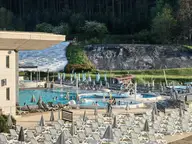 Outdoor thermal pools and sun loungers at Saliris Resort with the white travertine hill behind