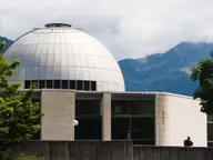 Silver dome of the Alpentherme Gastein in Bad Hofgastein with green mountains behind