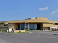 Curved sand colored main building of St. Martins Therme in Frauenkirchen under a blue sky