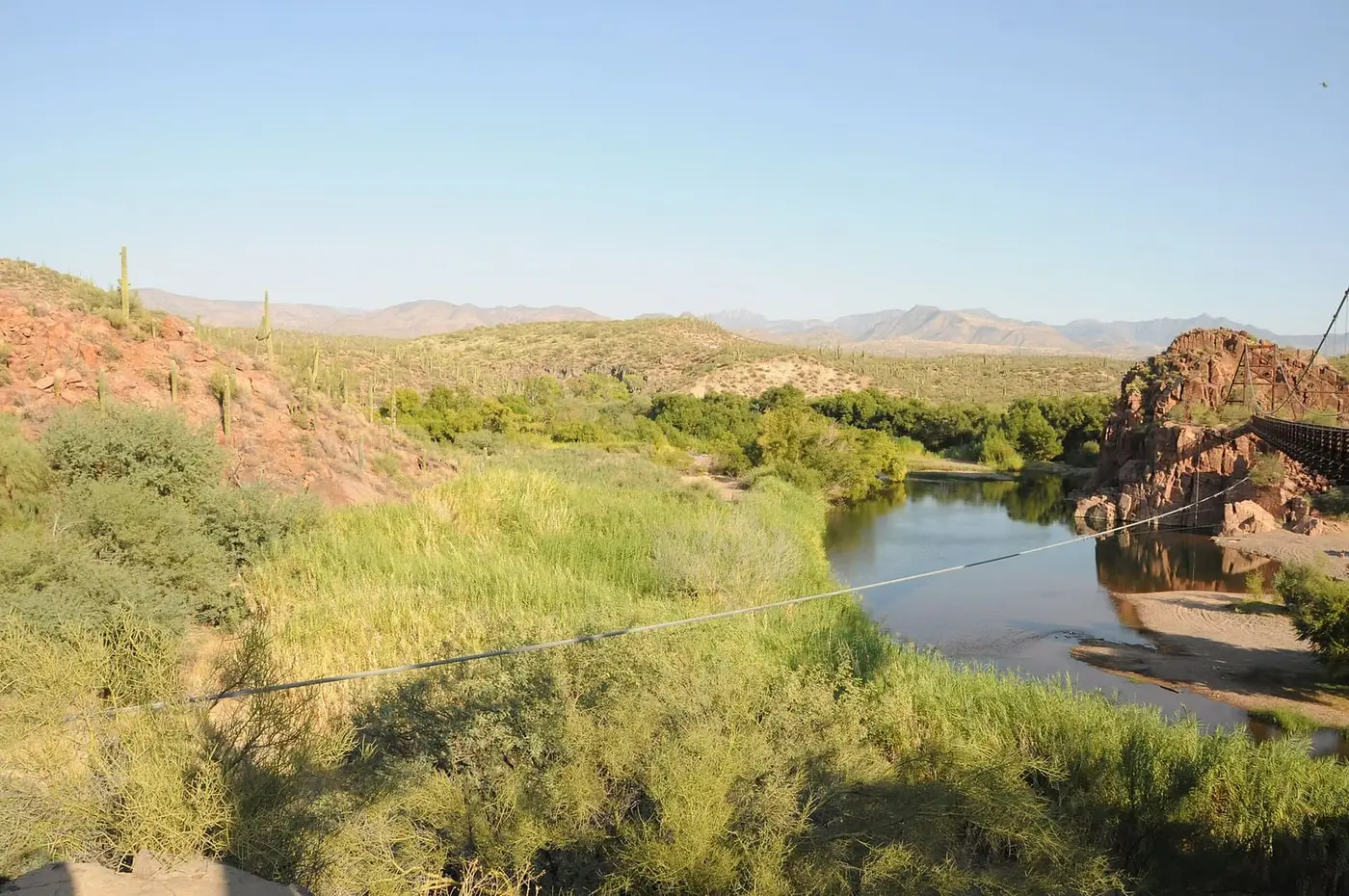 Verde River lined with green reeds and rocky banks where Sheep Bridge Hot Springs hides