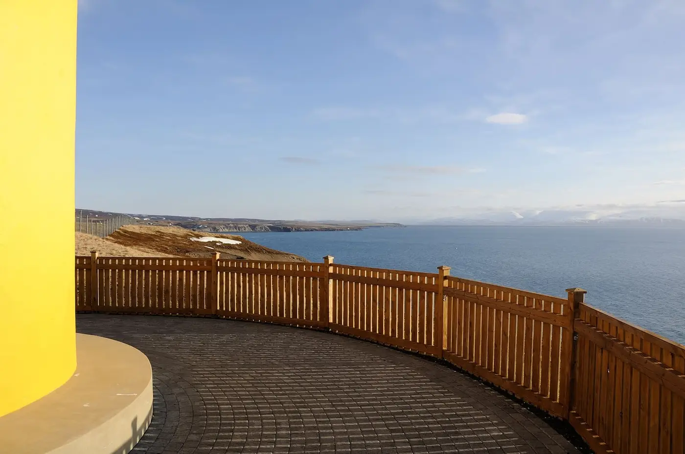 View from the yellow lighthouse on the Húsavík headland across Skjálfandi Bay to snowy mountains