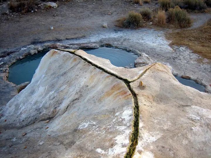 Blue hot pools beside a cracked travertine mound at Travertine Hot Springs near Bridgeport