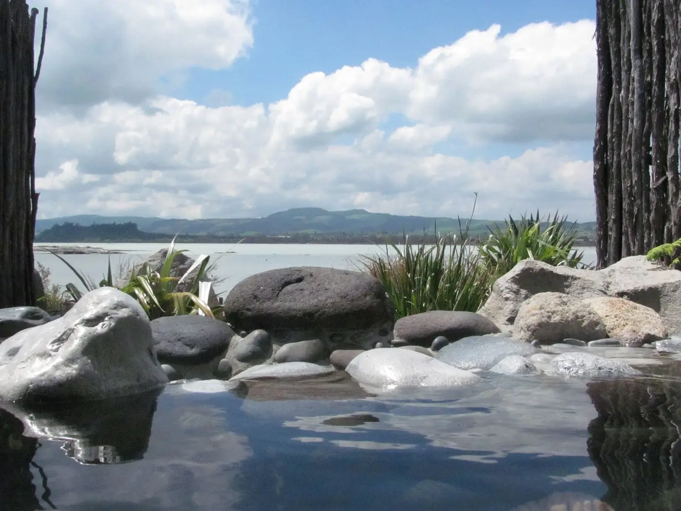 Boulder edged thermal pool at Polynesian Spa looking out over Lake Rotorua and distant hills