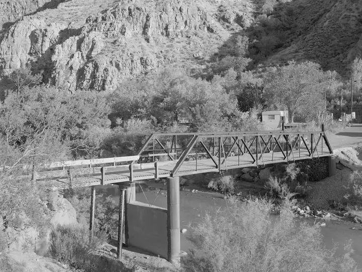 Black and white view of the old Hurricane LaVerkin truss bridge over the Virgin River in its rocky gorge
