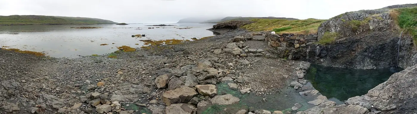 Panorama of the rock edged Hellulaug hot pot on the shore of Vatnsfjörður