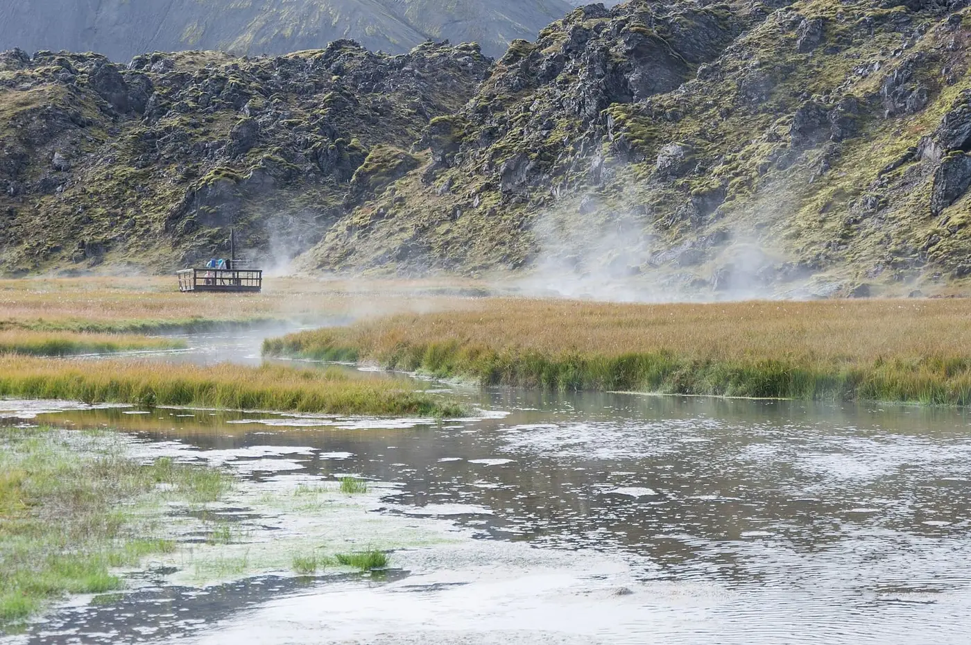 Steam rising over the warm stream at the edge of the Laugahraun lava field in Landmannalaugar