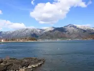 Lake Kawaguchi under blue sky with snowy mountains, the lakeside setting of Kawaguchiko Onsen